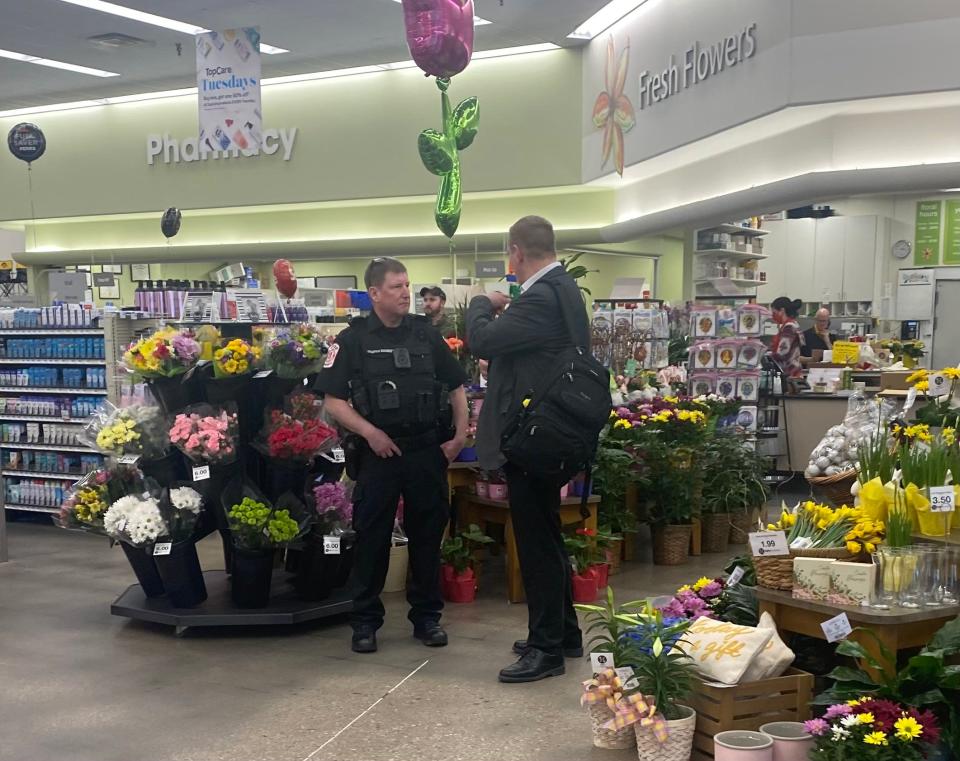 A Hy-Vee security guard talks with a customer at the Hy-Vee grocery store on 1st Avenue in Iowa City on April 5, 2022.