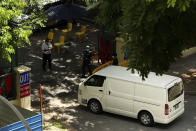 Police officers inspect a vehicle entering the WestLite Toh Guan dormitory, which has been declared an isolation area under the Infectious Diseases Act, following a spike in the number of COVID-19 cases in several foreign worker dormitories in Singapore, Friday, April 10, 2020. The tiny city-state of Singapore, with under six million people, has been hailed as a model in its swift response to the virus in the early days. But it overlooked the massive pool of migrant workers living in close quarters where social distancing is impossible and conditions are ripe for the virus spread. (AP Photo)