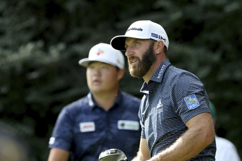 Dustin Johnson, right, reacts after teeing off on the 14th hole next to Sungjae Im during the final round of the Masters golf tournament Sunday, Nov. 15, 2020, in Augusta, Ga. (Curtis Compton/Atlanta Journal-Constitution via AP)