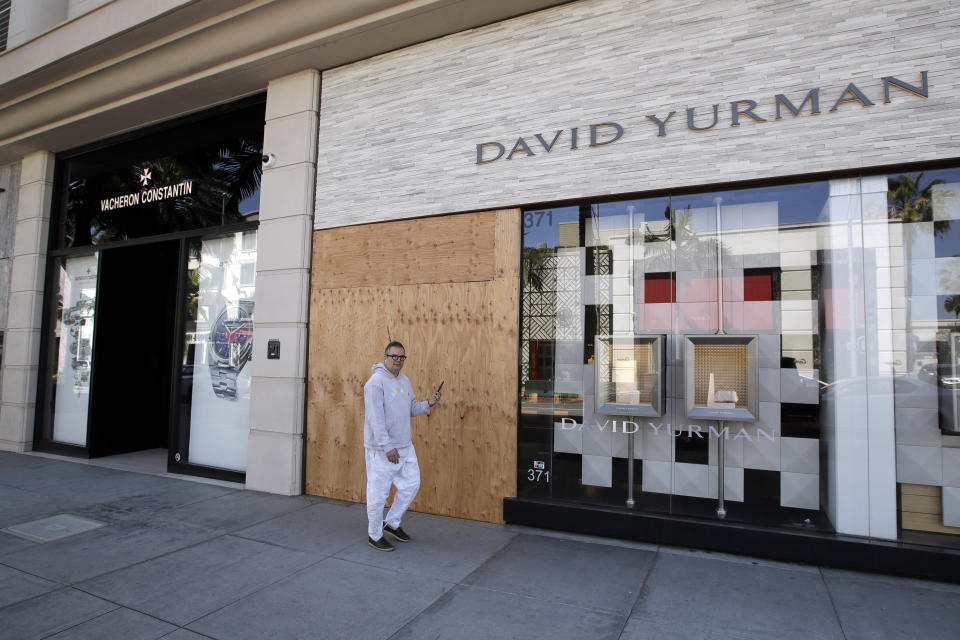 The entrance to the David Yurman store is boarded up on Rodeo Drive Monday, March 30, 2020, in Beverly Hills, Calif. Over the weekend, more people appeared to heed the message to stay home after beaches and many parks were closed by state and local officials following a swarm of visitors during the first weekend of the state's stay-at-home order in reaction to the coronavirus pandemic. (AP Photo/Marcio Jose Sanchez)