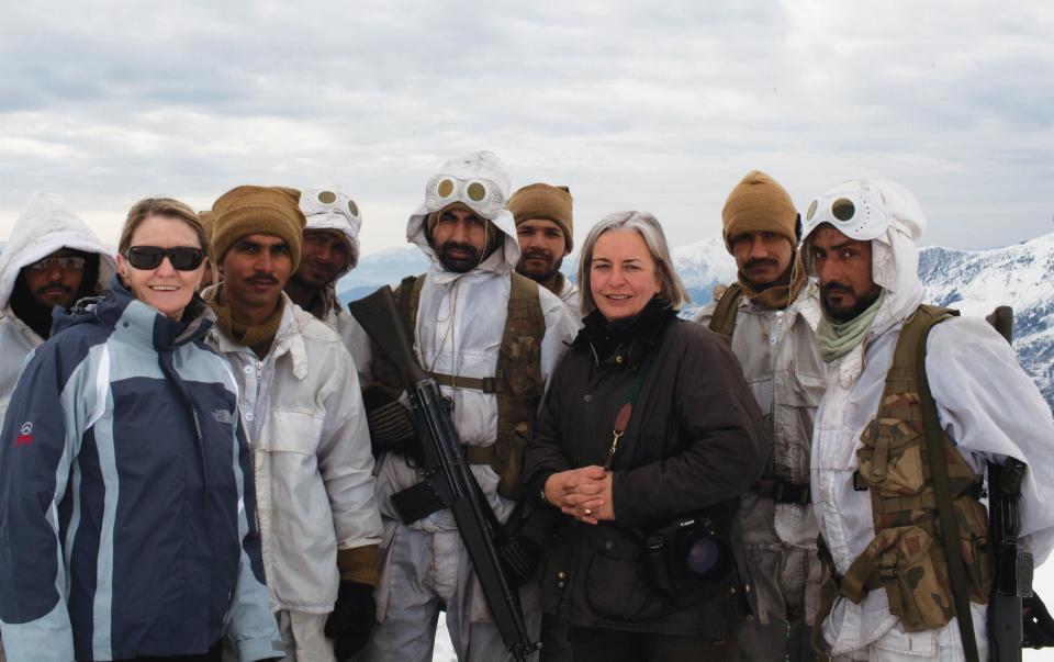 In this Feb. 2012 photo, Kathy Gannon, front left, AP special correspondent for Afghanistan and Pakistan, and veteran AP photographer Anja Niedringhaus, third right, pose with Pakistani soldiers in the remote border area opposite Afghanistan's northeastern Kunar province. The AP team was documenting Pakistan's role in fighting Islamic militants in the region. Niedringhaus, 48, was killed and Gannon was wounded on Friday, April 4, 2014 when an Afghan policeman opened fire while they were sitting in their car in eastern Afghanistan. (AP Photo)