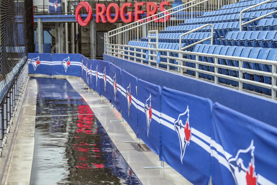 Rain delays the start of the baseball game between the Los Angeles Angels and Toronto Blue Jays on Sunday, April 11, 2021, in Dunedin, Fla. (AP Photo/Mike Carlson)