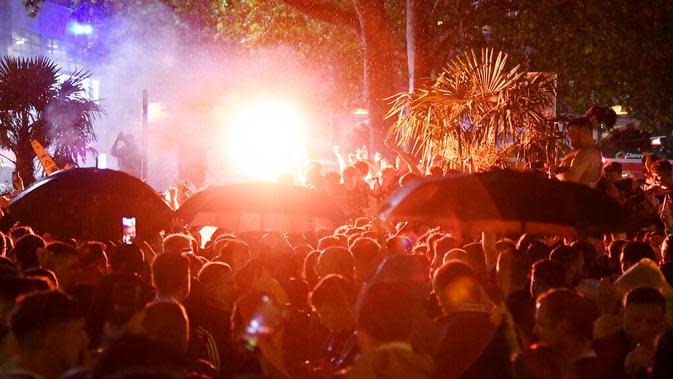Ribuan suporter Skotlandia berkumpul dan menyalakan flare di Leicester Square di London, Jumat (18/6/2021). (AP/Alberto Pezzali)