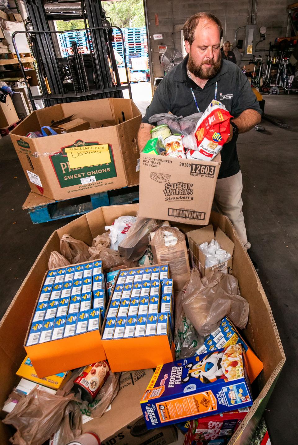 Interfaith Emergency Services driver Bruce Reed fills a box with donated food from local churches on May 3.
