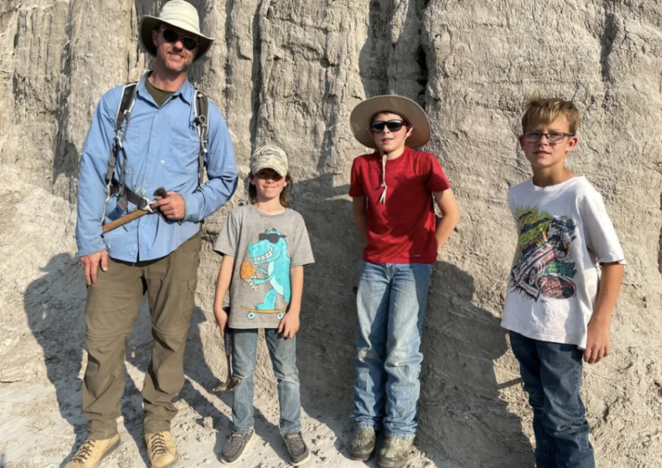 Vertebrate paleontologist Tyler Lyson, left, poses with young fossil finders Liam Fisher, Jessin Fisher and Kaiden Madsen (David Clark/Giant Screen Films via AP)