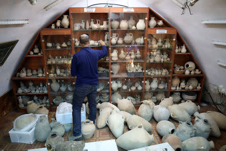 Eitan Klein, deputy director of the Israel Antiquities Authority's robbery prevention unit, checks items inside a shop selling antiques at a market in Jerusalem's Old City November 25, 2018. REUTERS/Corinna Kern