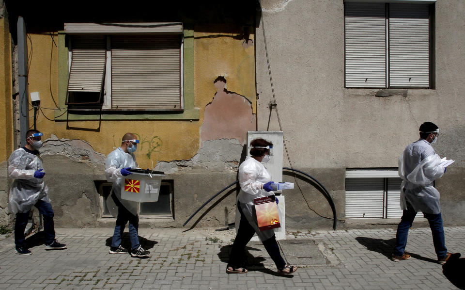 Members of a special election team with a ballot box and voting material make their way to voters who have tested positive for COVID-19 or are in self-isolation, in Skopje, North Macedonia, Monday, July 13, 2020. North Macedonia holds its first parliamentary election under its new country name this week, with voters heading to the polls during an alarming spike of coronavirus cases in the small Balkan nation. Opinion polls in the run-up to Wednesday’s vote indicate a close race between coalitions led by the Social Democrats and the center-right opposition VMRO-DPMNE party. (AP Photo/Boris Grdanoski)