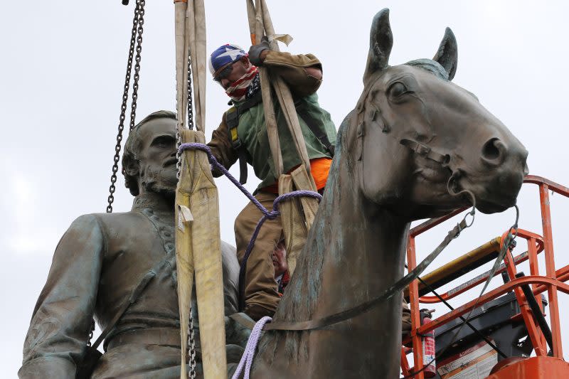 A worker attaches a rope as they prepare to remove the statue of Confederate General Stonewall Jackson from its pedestal on July 1, 2020, in Richmond, Va. Shenandoah County, Virginia’s school board voted 5-1 early Friday, May 10, 2024, to rename Mountain View High School as Stonewall Jackson High School and Honey Run Elementary as Ashby Lee Elementary four years after the names had been removed. AP Photo/Steve Helber, File)