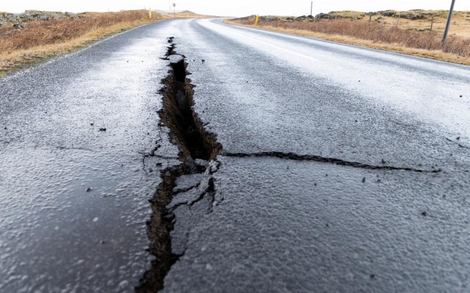 Cracks emerge on a road due to volcanic activity at the entrance to Grindavik, Iceland