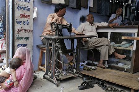 A tailor (R) waits for customers at his shop at Kasba Bonli town in the desert Indian state of Rajasthan October 30, 2013. REUTERS/Shyamantha Asokan