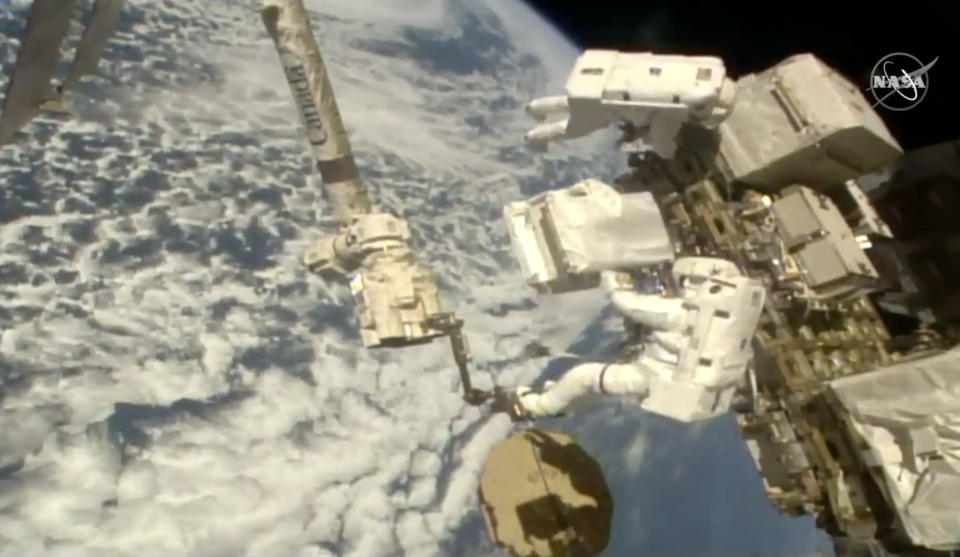 In this image taken from NASA video Italian astronaut Luca Parmitano, lower right, holds a bundle of new pumps for the Alpha Magnetic Spectrometer as he and U.S. astronaut Andrew Morgan work to revitalize a cosmic ray detector outside the International Space Station on Monday, Dec. 2, 2019. Monday’s spacewalk is the third in nearly three weeks for the pair and is the culmination of years of work to repair the Alpha Magnetic Spectrometer. (NASA via AP)