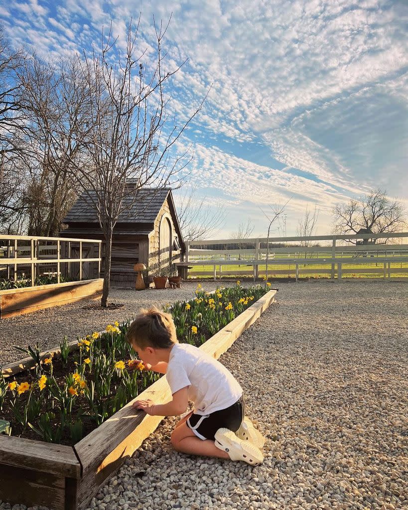 Crew kneeling on the ground by some daffodils