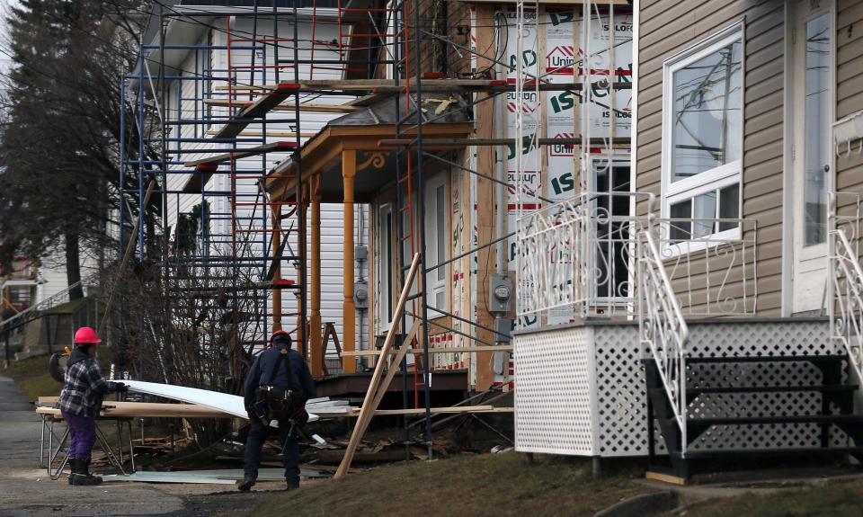 Construction workers work on a house in Lac-Megantic