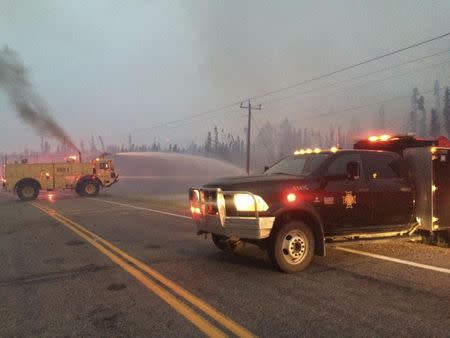 Firefighters tackle a wildfire near the town of La Ronge, Saskatchewan July 4, 2015 in a picture provided by the Saskatchewan Ministry of Government Relations. REUTERS/Saskatchewan Ministry of Government Relations/Handout via Reuters