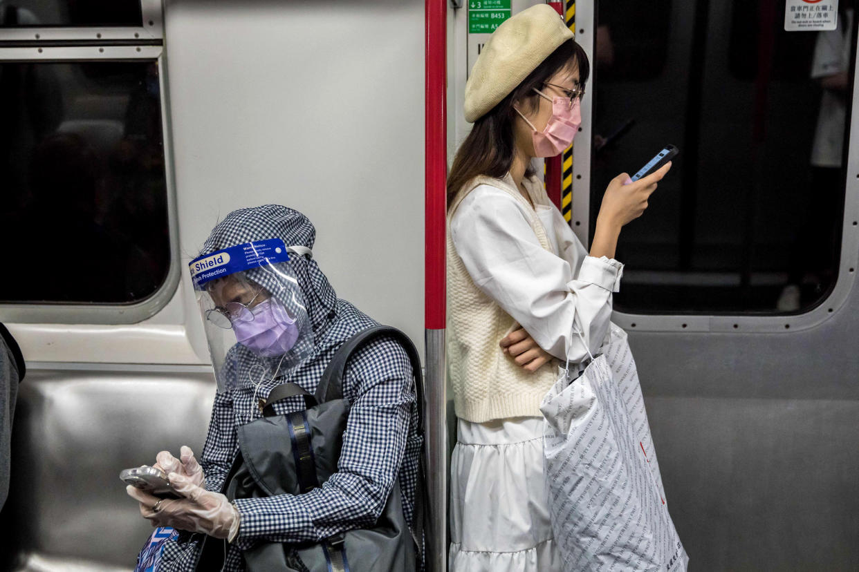 People wearing face masks as a preventive measure against COVID-19 commute on a train in Hong Kong. (AFP via Getty Images)