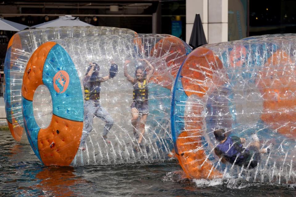 People enjoy the hot weather as they zorb on the canal at Paddington Basin in London (Joe Sene/PA) (PA Wire)