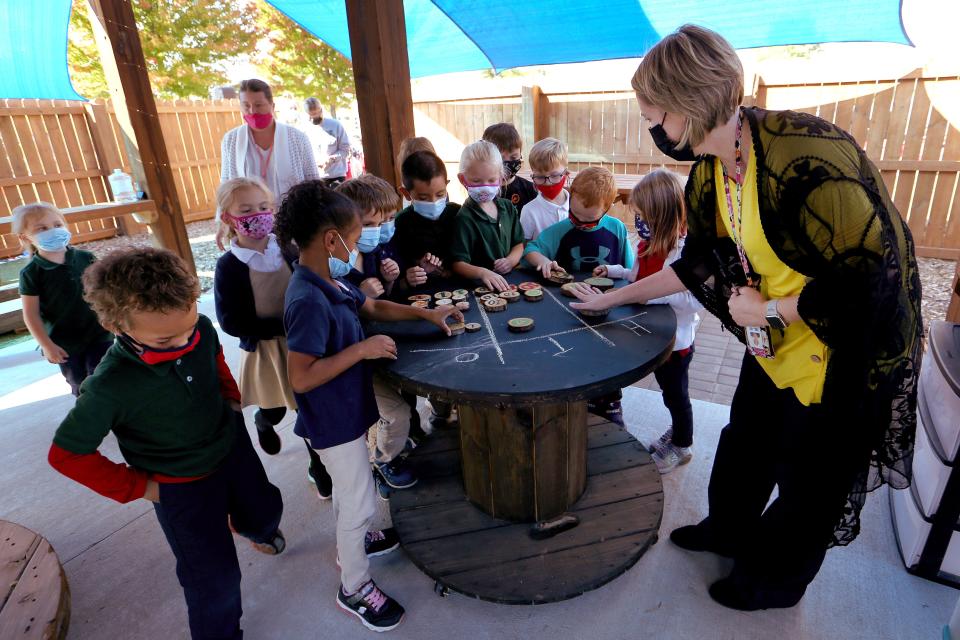 Kindergarten teacher Tara Urban looks at the numbers learning game with her kindergartners Thursday afternoon during the grand opening of the outdoor classroom at the Magnet School at Allen. 