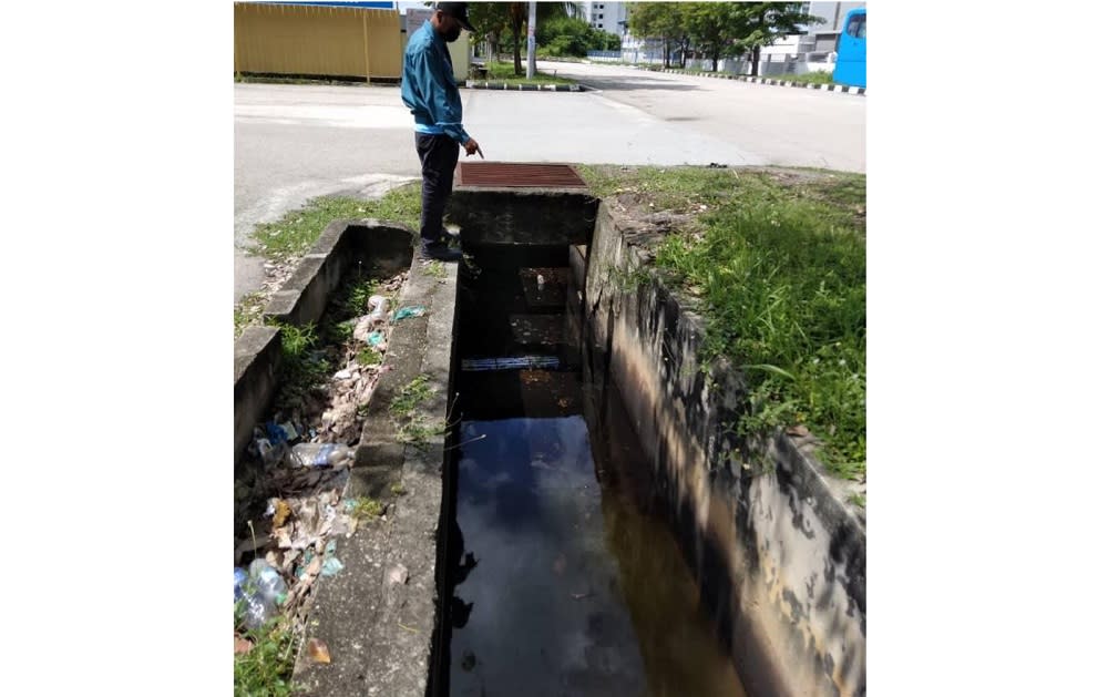 Officers from the Department of Enviromental collecting samples as they issue a fine to a factory in Bukit Minyak May 3, 2021. — Picture courtesy of DOE