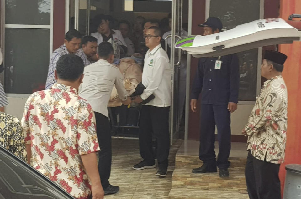 Indonesian medics wheel Indonesian Coordinating Minister for Politics, Law and Security Wiranto on a stretcher to an ambulance to be evacuated to Jakarta, at a hospital in Pandeglang, Banten province, Indonesia, Thursday, Oct. 10, 2019. Police say a knife-wielding man has wounded the top security minister, a local police chief and another person in a western province. (AP Photo)