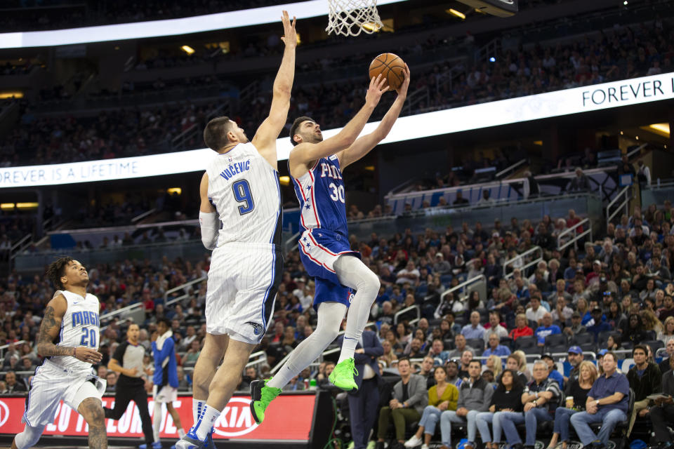 Philadelphia 76ers guard Furkan Korkmaz (30) attempts to lay up the ball against Orlando Magic center Nikola Vucevic (9) during the first half of an NBA basketball game in Orlando, Fla., Friday, Dec. 27, 2019. (AP Photo/Willie J. Allen Jr.)