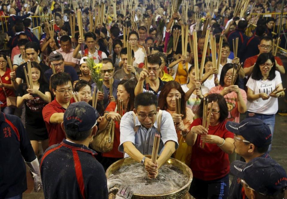 People rush to plant the first joss stick of the Lunar New Year of the Monkey at the stroke of midnight at the Kwan Im Thong Hood Cho temple on 8 February. Photo: Reuters/Edgar Su.