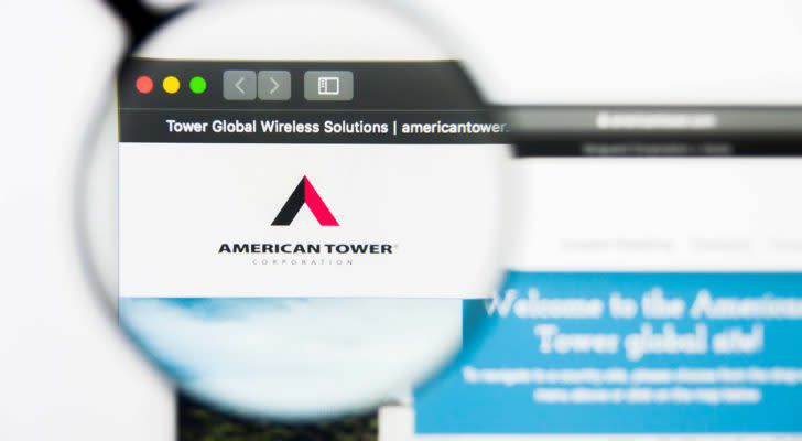 A magnifying glass zooms in on the American Tower (AMT) website.