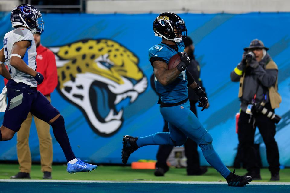 Jacksonville Jaguars linebacker Josh Allen (41) scores a 37-yard touchdown on a fumble return as Tennessee Titans wide receiver Robert Woods (2) looks on during the fourth quarter of an NFL football regular season matchup AFC South division title game Saturday, Jan. 7, 2023 at TIAA Bank Field in Jacksonville. The Jacksonville Jaguars held off the Tennessee Titans 20-16. [Corey Perrine/Florida Times-Union]