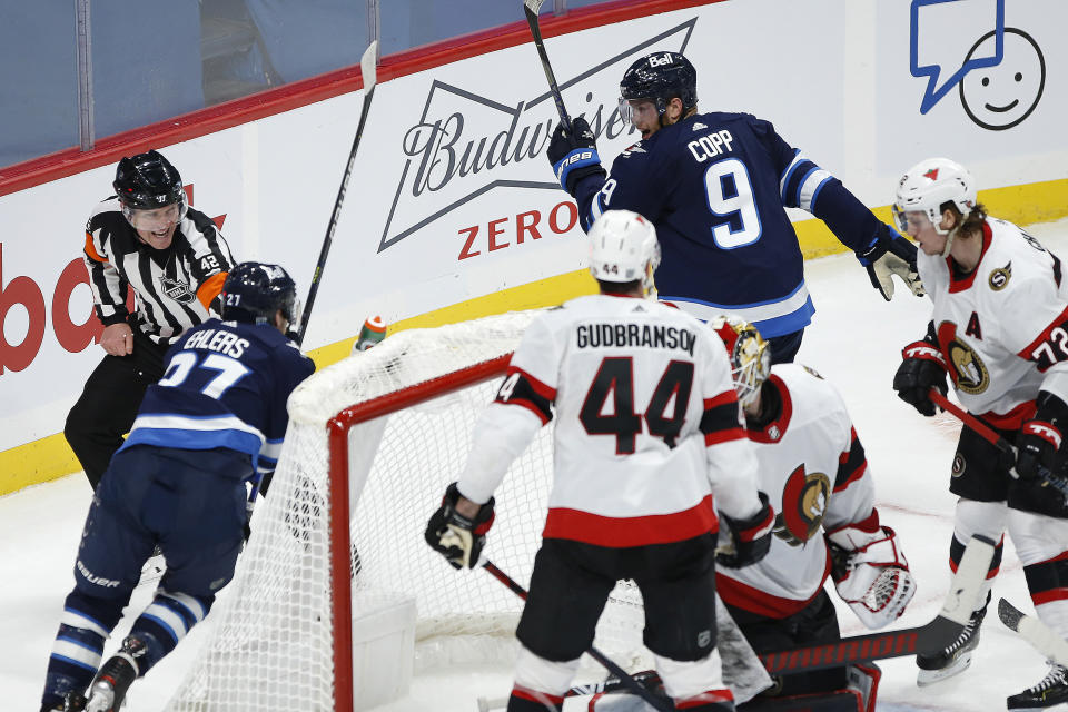 Winnipeg Jets' Andrew Copp (9) and Nikolaj Ehlers (27) celebrate Copp's goal on Ottawa Senators goaltender Marcus Hogberg during the third period of an NHL hockey game Saturday, Jan. 23, 2021, in Winnipeg, Manitoba. (John Woods/The Canadian Press via AP)