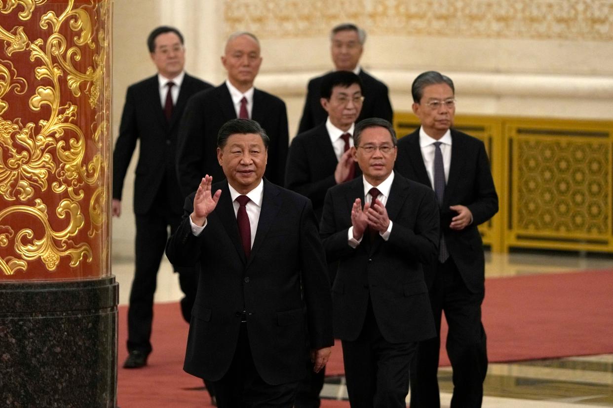 New members of the Politburo Standing Committee, front to back, President Xi Jinping, Li Qiang, Zhao Leji, Wang Huning, Cai Qi, Ding Xuexiang, and Li Xi arrive at the Great Hall of the People in Beijing, Sunday, Oct. 23, 2022. 