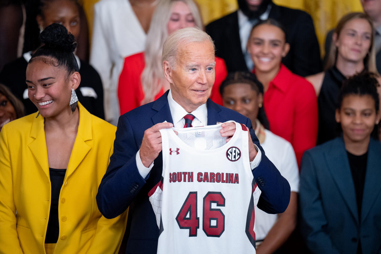 WASHINGTON, DC - SEPTEMBER 10: U.S. President Joe Biden holds up a team jersey given to him during an event to celebrate the 2023-2024 University of South Carolina Gamecocks Women's Basketball NCAA championship team in the East Room at the White House on September 10, 2024 in Washington, DC. The Gamecocks ended their season undefeated and beat the Iowa Hawkeyes 87-75 for their third NCAA Championship with Head Coach Dawn Staley. (Photo by Andrew Harnik/Getty Images)