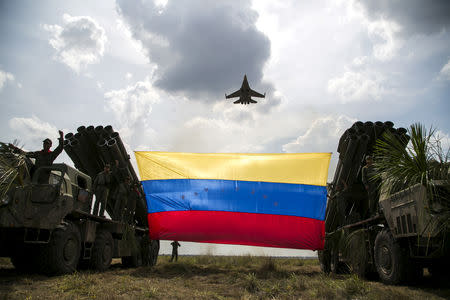 FILE PHOTO: A Russian-made Sukhoi Su-30MKV fighter jet of the Venezuelan Air Force flies over a Venezuelan flag tied to missile launchers, during the "Escudo Soberano 2015" (Sovereign Shield 2015) military exercise in San Carlos del Meta in the state of Apure April 15, 2015. REUTERS/Marco Bello/File Photo