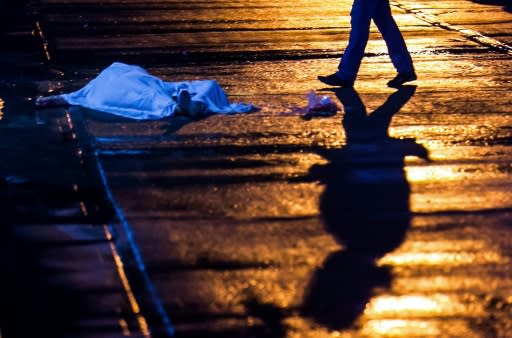 A shadow falls near the woman's shrouded corpse