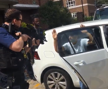 Police caught on video pointing assault rifles at two men holding hands up in London