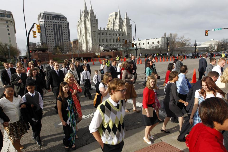FILE - This April 6, 2013, file photo, shows the Salt Lake Temple as people walk to the Conference Center before the start of the 183rd Annual General Conference of The Church of Jesus Christ of Latter-day Saints, in Salt Lake City. More than 100,000 Latter-day Saints are expected in Salt Lake City this weekend for the church's biannual general conference. Leaders of The Church of Jesus Christ of Latter-day Saints give carefully crafted speeches aimed at providing members with guidance and inspiration in five sessions that span Saturday and Sunday. They also make announcements about church statistics, new temples or initiatives. In addition to those filling up the 21,000-seat conference center during the sessions, thousands more listen or watch around the world in 95 languages on television, radio, satellite and Internet broadcasts. A Mormon's women group pushing the church to allow women in the priesthood plans to demonstrate outside an all-male meeting Saturday. The church has asked them to reconsider, and barred media from going on church property during the demonstration. (AP Photo/Rick Bowmer, File)