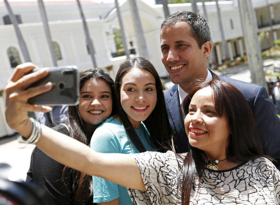 Venezuelan opposition leader Juan Guaido, who has declared himself interim president, poses for selfie photo with supporters after a meeting with "Frente Amplio," a coalition of opposition parties, and other civic groups in Caracas, Venezuela, Monday, March 18, 2019. After Guaido declared himself interim president in late Feb., Venezuelan President Nicolas Maduro has remained in power despite heavy pressure from the United States and other countries arrayed against him, managing to retain the loyalty of most of his military leaders. (AP Photo/Natacha Pisarenko)