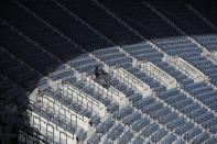FILE - In this April 21, 2020, file photo, a TV cameraman works in rows of empty seats during a preseason baseball game between Doosan Bears and LG Twins in Seoul, South Korea. (AP Photo/Lee Jin-man, File)