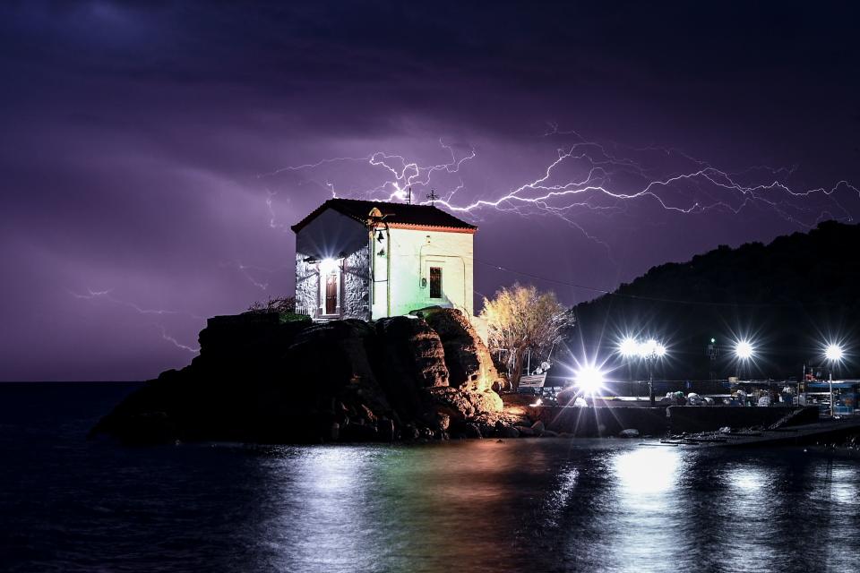 TOPSHOT – Lightning strikes behind the chapel of Panagia Gorgona in the village of Skala Sykamias, north of Lesbos, on February 27, 2020. (Photo by ARIS MESSINIS / AFP) (Photo by ARIS MESSINIS/AFP via Getty Images)