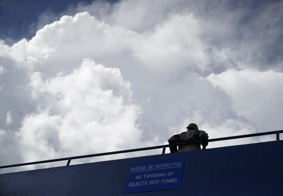 Storm clouds build over a cadet on a bridge over the tunnel leading to the lockerrooms at Falcom Stadium after an NCAA college football game Saturday, Sept. 1, 2018, at Air Force Academy, Colo. Air Force won 38-0 over Stony Brook. The game was delayed twice because of threatening weather. (AP Photo/David Zalubowski)