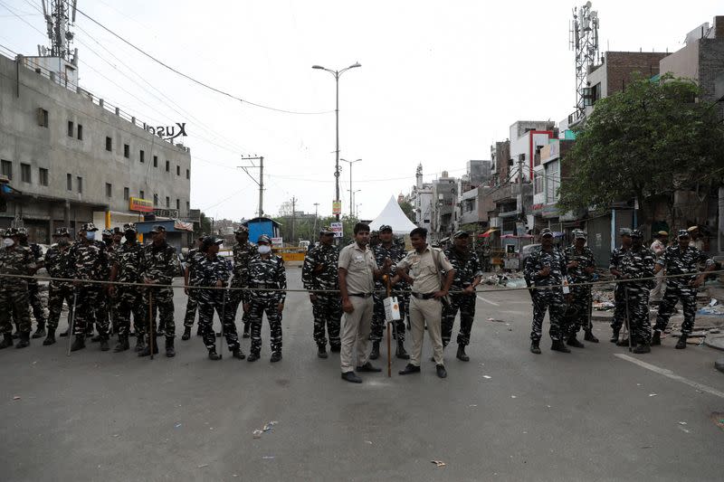 Police and paramilitary forces stand guard near the barricades put up after Wednesday's demolition of illegal encroachments, in Jahangirpuri