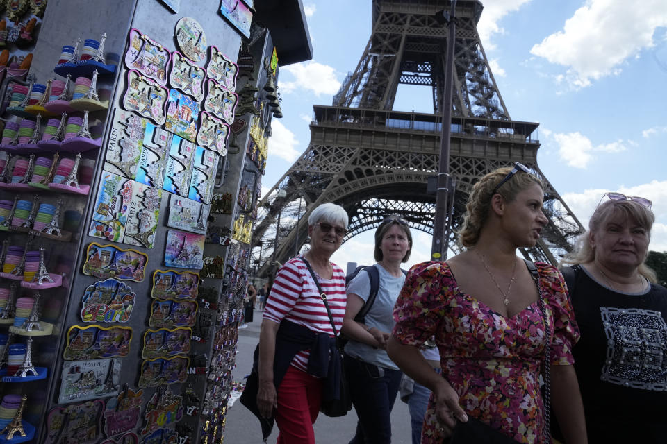 Tourists walk back from the Eiffel Tower, Thursday, July 6, 2023 in Paris. French government officials met with representatives of the tourism industry to discuss repercussions of unrest sparked by the police killing of a 17-year-old boy on tourist activity and on France's international image. The shooting death of Nahel Merzouk, who was of north African descent, prompted nationwide anger over police tactics and entrenched discrimination against people in low-income neighborhoods around France where many trace their roots to former French colonies. (AP Photo/Michel Euler)