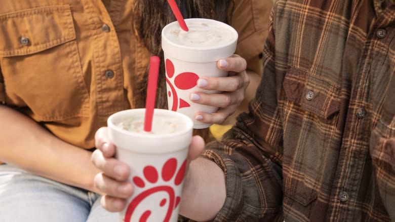 People holding milkshake cups