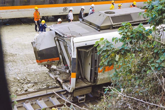 台鐵太魯閣號事故列車，嚴重破損的第7節車廂6日下午拖出隧道，第8節車廂幾乎成廢鐵，工程人員還在想辦法拖出。（王志偉攝）