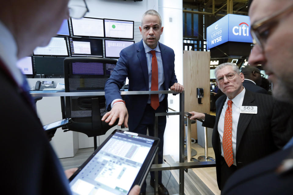 Director of Trading Floor Operations Fernando Munoz, center, works with the traders during a trading halt on the floor of the New York Stock Exchange, Monday, March 9, 2020. The Dow Jones Industrial Average plummeted 1,500 points, or 6%, following similar drops in Europe after a fight among major crude-producing countries jolted investors already on edge about the widening fallout from the outbreak of the new coronavirus. (AP Photo/Richard Drew)