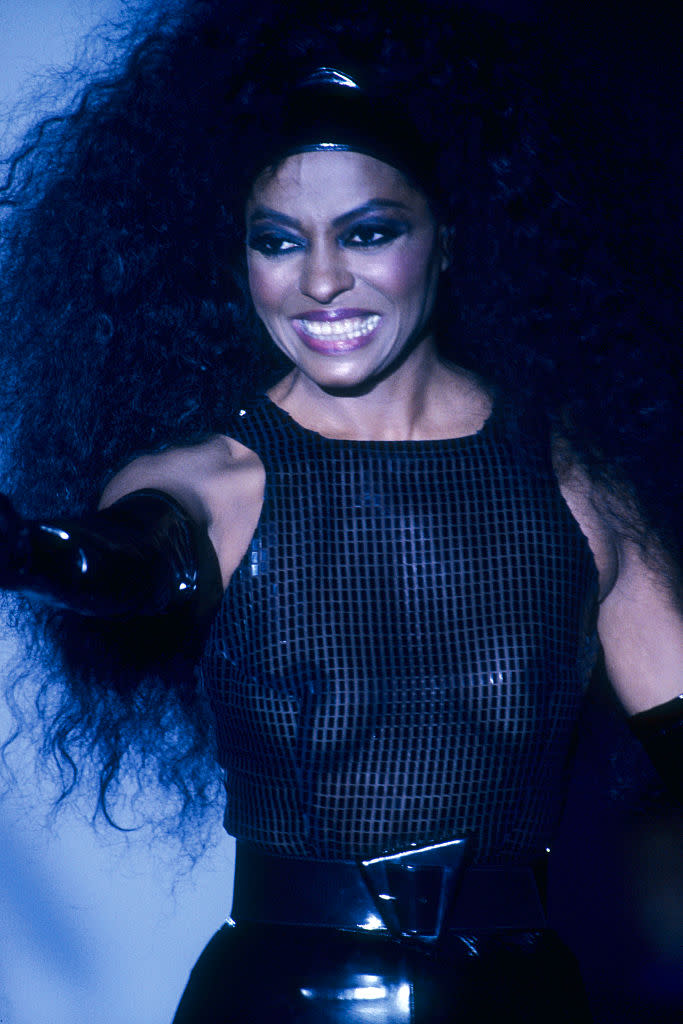Singer Diana Ross models ready-to-wear women's fashions at a 1990 spring-summer fashion show for French fashion house Thierry Mugler in Paris. She wears a sheer tank top, vinyl gloves, and headband, all in black. (Photo by julio donoso/Sygma via Getty Images)
