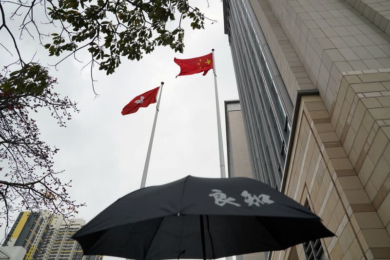 Chinese and Hong Kong flags flutter outside West Kowloon Magistrates' Courts in Hong Kong