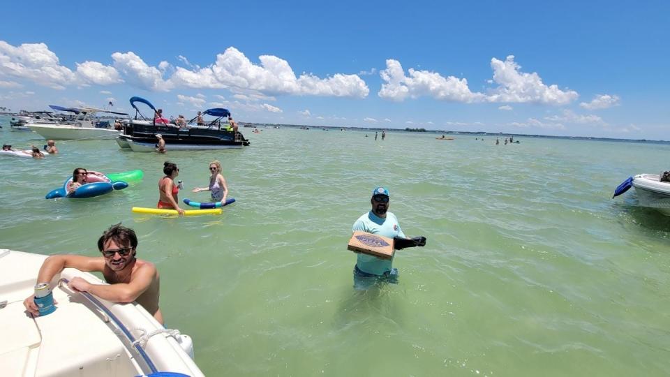 Sean Ferraro delivers pizza to swimmers and people in boats.