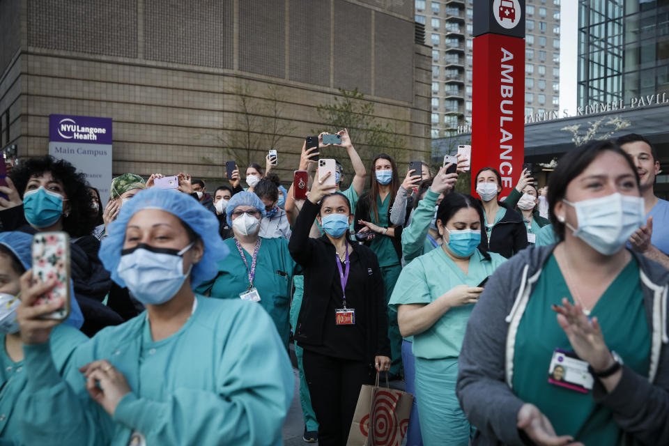 FILE - In this April 28, 2020, file photo Medical personnel attend a daily 7 p.m. applause in their honor, during the coronavirus pandemic outside NYU Langone Medical Center in the Manhattan borough of New York. Essential workers are lauded for their service and hailed as everyday heroes. But in most states nurses, first responders and frontline workers who get COVID-19 on the job have no guarantee they'll qualify for workers' comp to cover lost wages and medical care. (AP Photo/John Minchillo, File)