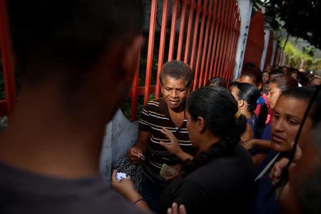 A woman receives a numbered ticket while she queues to try and buy food outside a market in Caracas, Venezuela March 17, 2017. REUTERS/Carlos Garcia Rawlins SEARCH "GARCIA QUEUEING" FOR THIS STORY. SEARCH "WIDER IMAGE" FOR ALL STORIES.