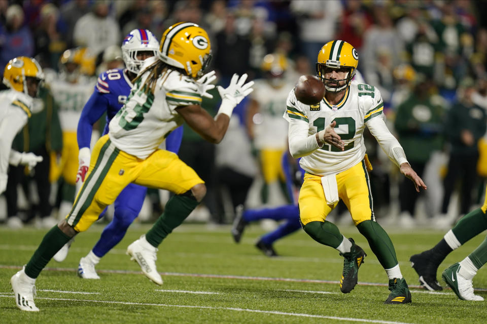 Green Bay Packers quarterback Aaron Rodgers (12) toss the ball to running back Aaron Jones (33)during the first half of an NFL football game against the Buffalo Bills Sunday, Oct. 30, 2022, in Orchard Park. (AP Photo/Seth Wenig)
