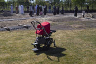 Family members pray after lowering the coffin of Mbarka Bouda into a grave at the Riyad Al Jannah, or Garden of Paradise, cemetery in Zuidlaren, northern Netherlands, Wednesday, May 6, 2020. As measures to stem the spread of the COVID-19 coronavirus grounded flights and closed borders around the world, even the dead are affected because their bodies cannot be flown home for burial in the places they were born. (AP Photo/Peter Dejong)